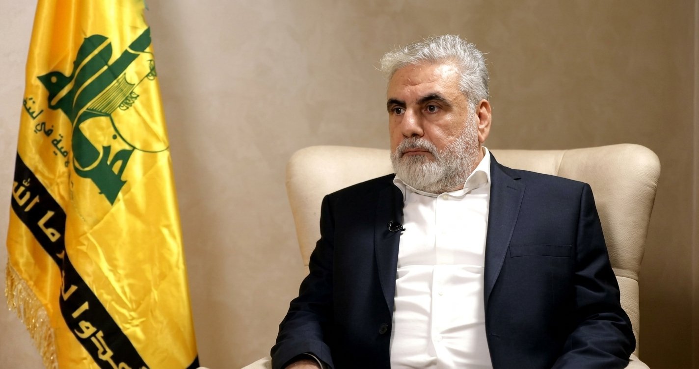Pejabat senior Hizbullah Nawaf al-Moussawi memberikan keterangan di depan bendera Hizbullah.