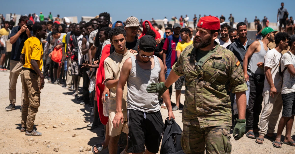 Tentara Spanyol mengawal barisan migran asal Maroko di kawasan perbatasan Ceuta.